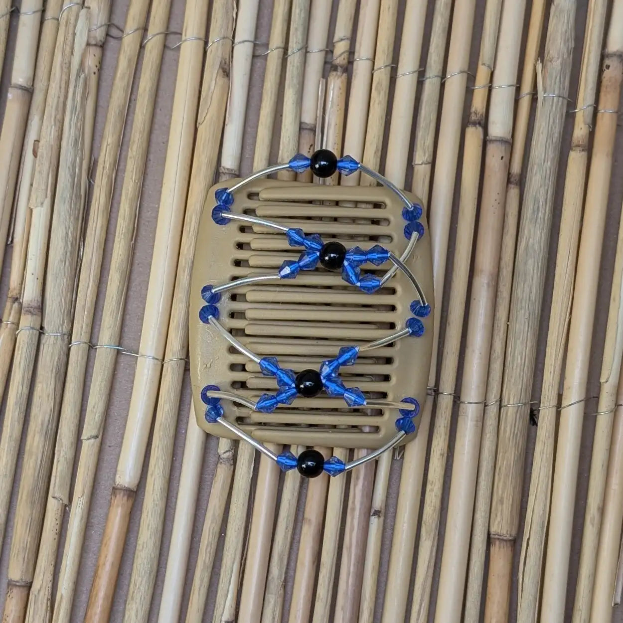 Beiger mittelgroßer African Butterfly Haarkamm mit hellblauen und schwarzen Kunstperlen mit feinen Metallstäben - flexibler Haarschmuck für Hochsteckfrisuren.