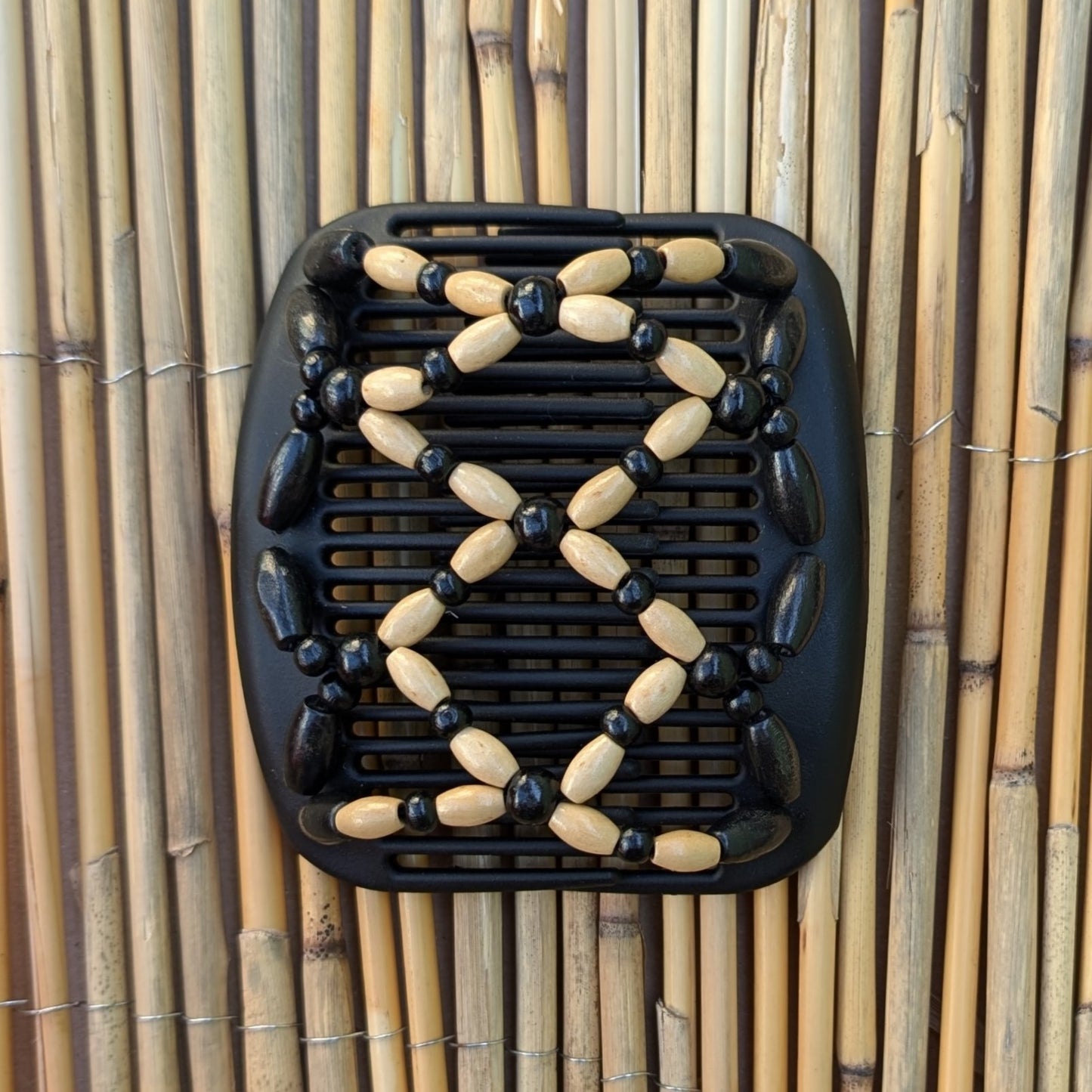 Schwarzer African Butterfly Haarkamm mit schwarzen und hellen Holzperlen – flexibler Haarschmuck für Hochsteckfrisuren.