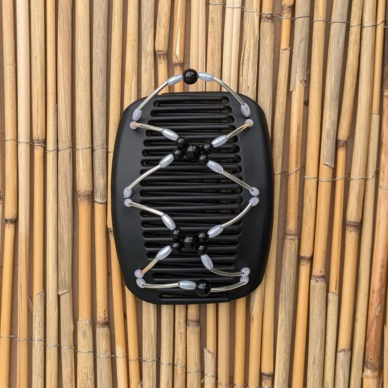 Schwarzer African Butterfly Haarkamm mit silbernen und schwarzen Kunstperlen mit feinen Metallstäben - flexibler Haarschmuck für Hochsteckfrisuren.