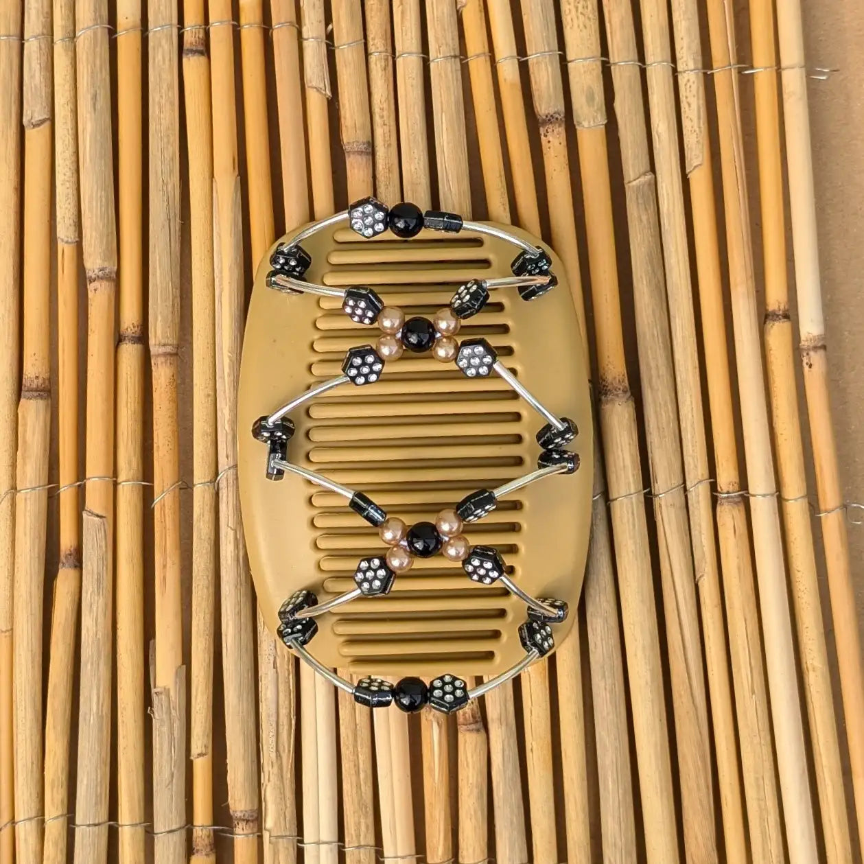 Beiger African Butterfly Haarkamm mit schwarzen und pfirsichfarbene Kunstperlen mit feinen Metallstäben - flexibler Haarschmuck für Hochsteckfrisuren.