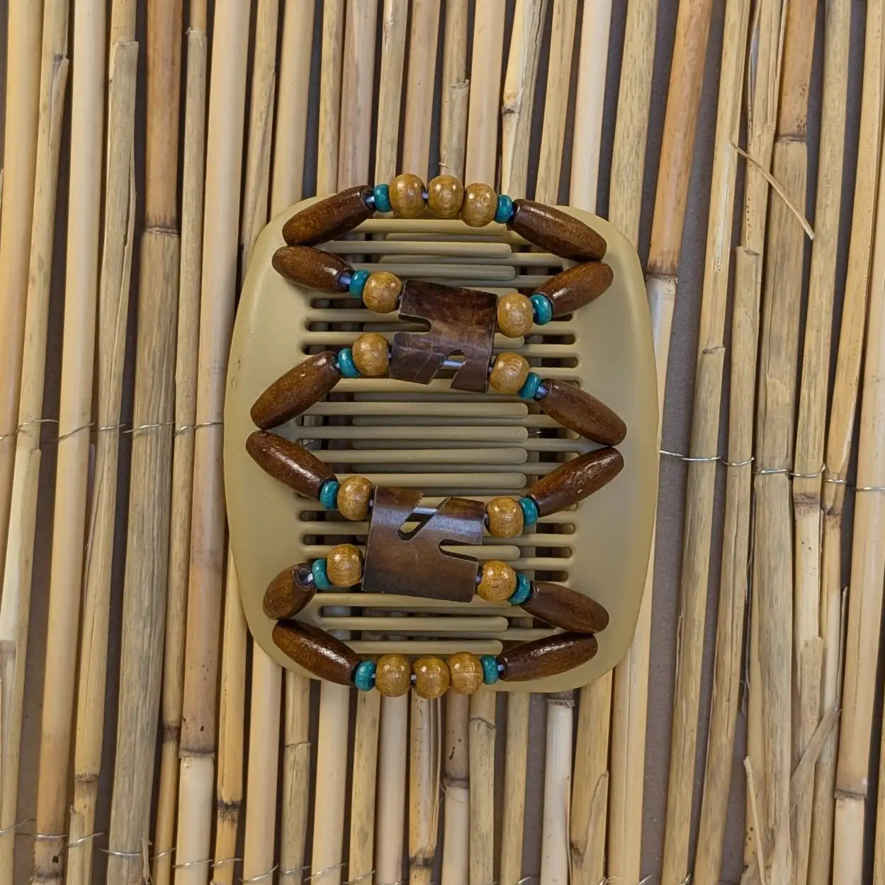 Beiger African Butterfly Haarkamm mit braunen und petrolfarben Holzperlen mit Elementen aus Horn in der Mitte - flexibler Haarschmuck für Hochsteckfrisuren.