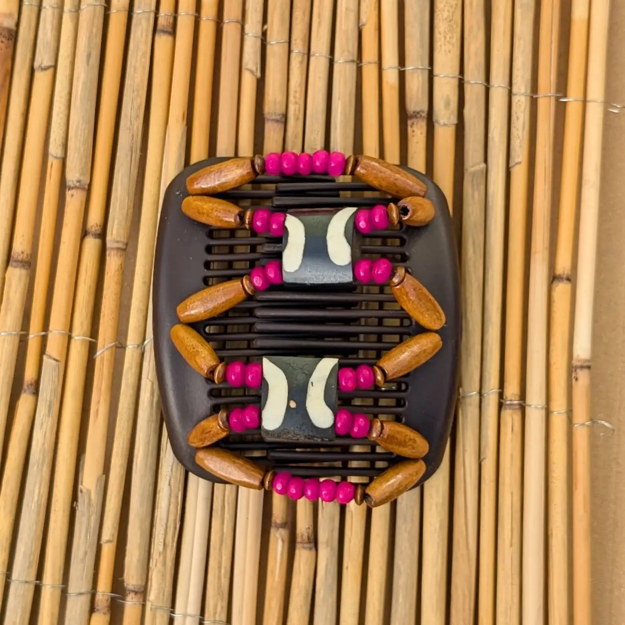 Brauner African Butterfly Haarkamm mit braunen und pinken Holzperlen mit Elementen aus Horn in der Mitte - flexibler Haarschmuck für Hochsteckfrisuren.