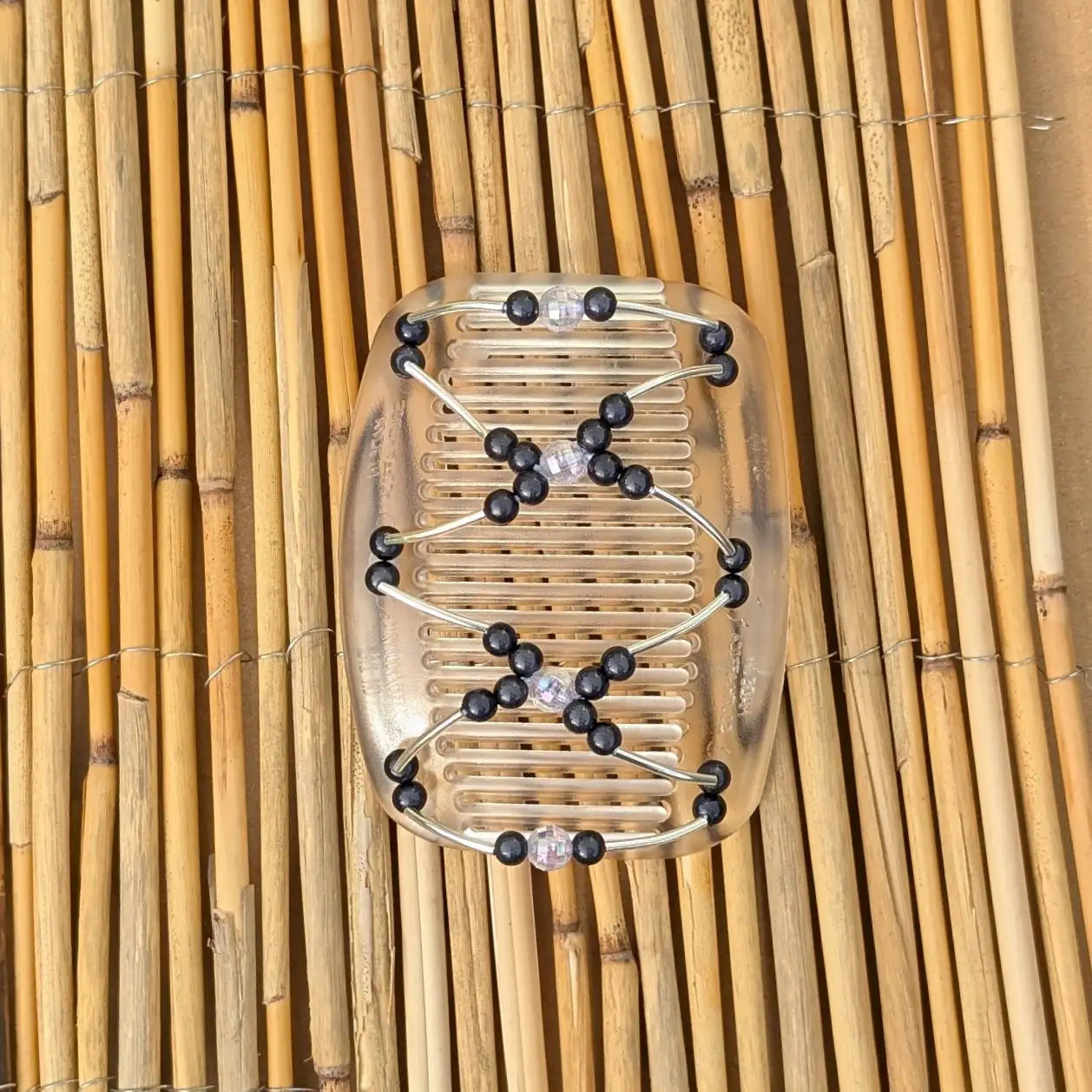 Durchsichtiger African Butterfly Haarkamm mit schwarzen und klaren Kunstperlen mit feinen Metallstäben - flexibler Haarschmuck für Hochsteckfrisuren.