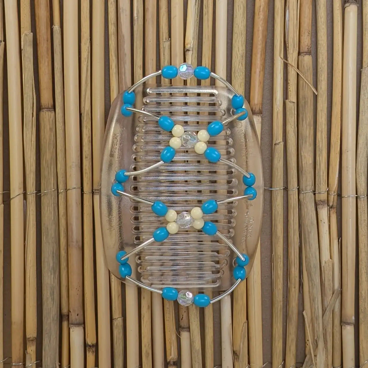 Durchsichtiger African Butterfly Haarkamm mit hellblauen und cremefarbenen Kunstperlen mit feinen Metallstäben - flexibler Haarschmuck für Hochsteckfrisuren.