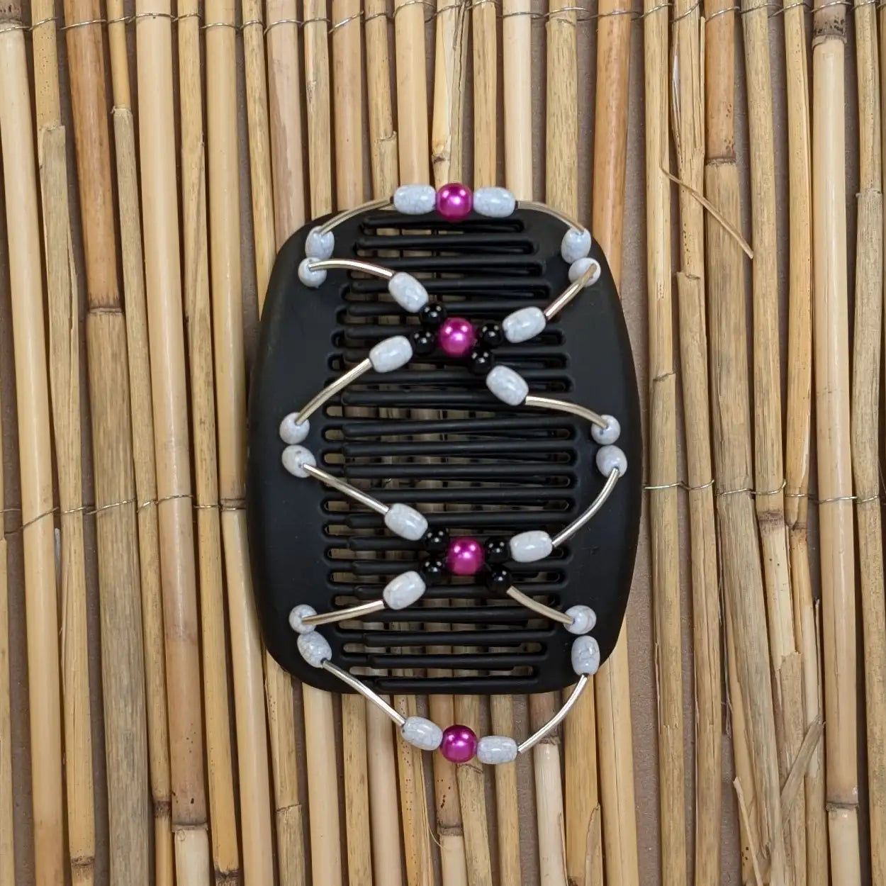 Schwarzer African Butterfly Haarkamm mit weißen, schwarzen und pinken Kunstperlen mit feinen Metallstäben - flexibler Haarschmuck für Hochsteckfrisuren.