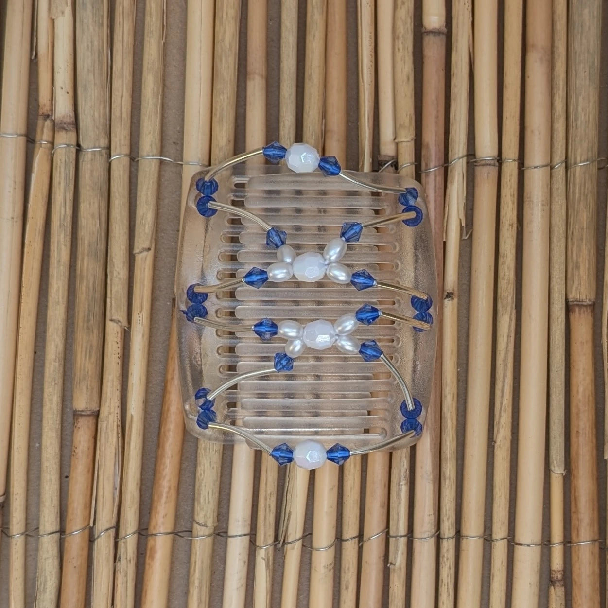 Durchsichtiger mittelgroßer African Butterfly Haarkamm mit blau und weißen Kunstperlen mit feinen Metallstäben - flexibler Haarschmuck für Hochsteckfrisuren.