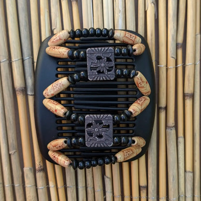 Schwarzer African Butterfly Haarkamm mit schwarzen und beigefarbenen Holzperlen mit roten Mustern und quadratischen Zierperlen in Blumenform– flexibler Haarschmuck für Hochsteckfrisuren.