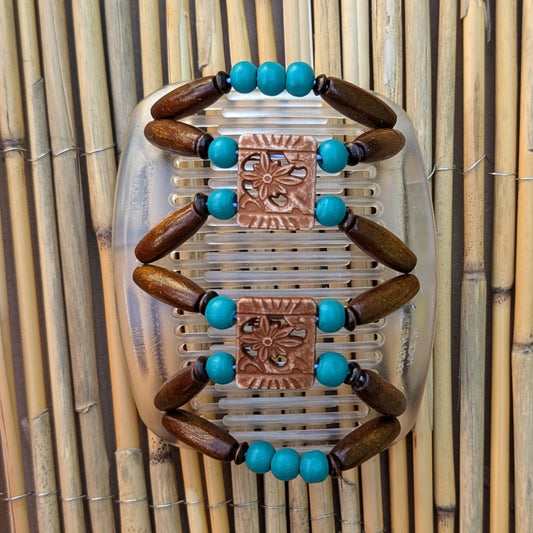 Durchsichtiger African Butterfly Haarkamm mit braun und türkisen Holzperlen und quadratischen Zierperlen in Blumenform– flexibler Haarschmuck für Hochsteckfrisuren.