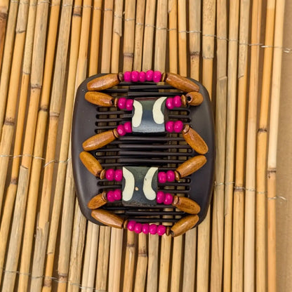 Brauner African Butterfly Haarkamm mit braunen und pinken Holzperlen mit Elementen aus Horn in der Mitte - flexibler Haarschmuck für Hochsteckfrisuren.