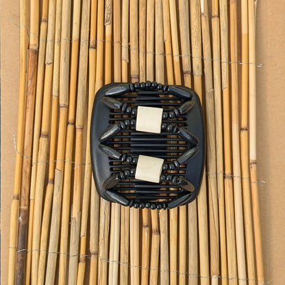 Schwarzer African Butterfly Haarkamm mit schwarz und weißen Holzperlen mit Elementen aus Horn in der Mitte - flexibler Haarschmuck für Hochsteckfrisuren.