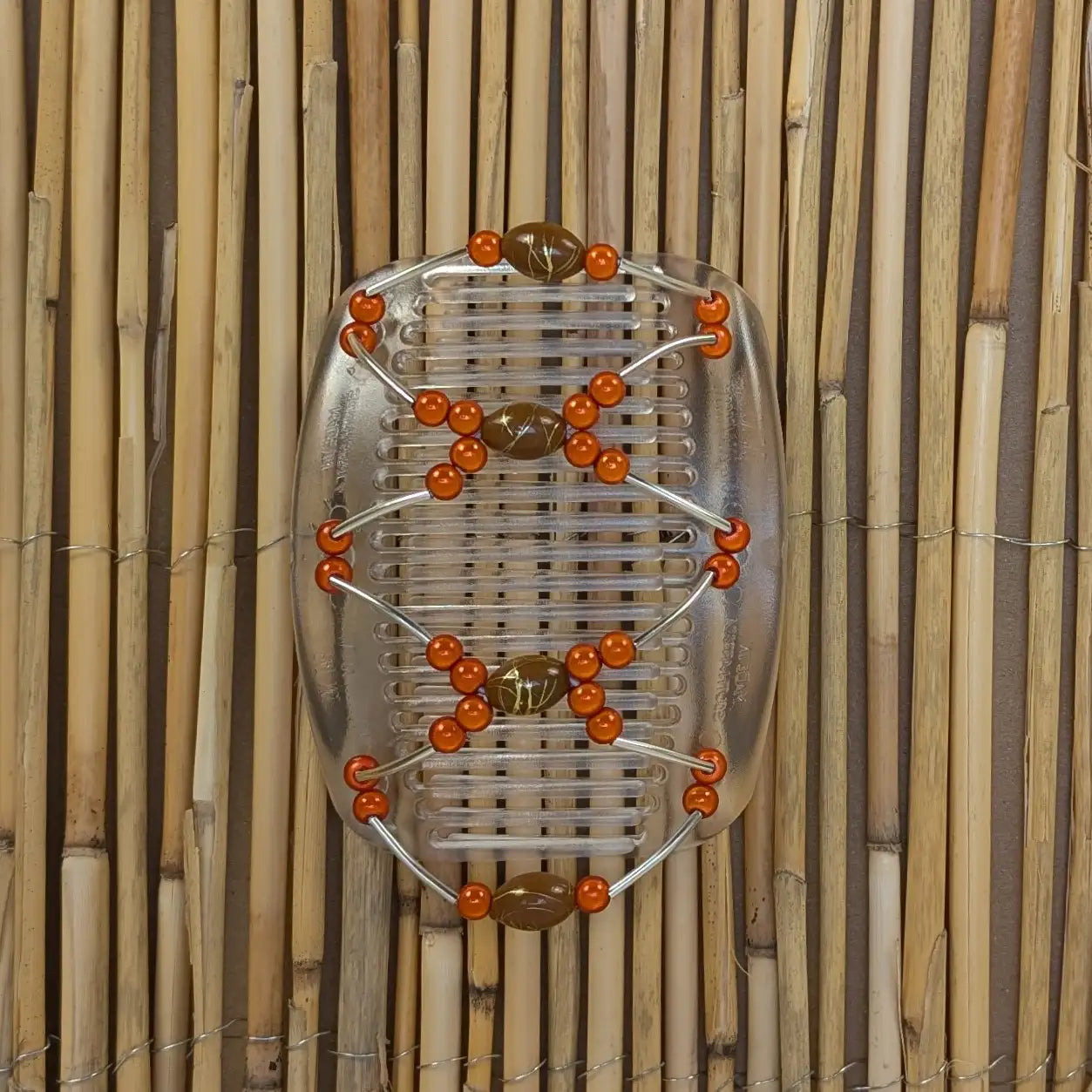 Durchsichtiger African Butterfly Haarkamm mit orangen und braunen Kunstperlen mit feinen Metallstäben - flexibler Haarschmuck für Hochsteckfrisuren.